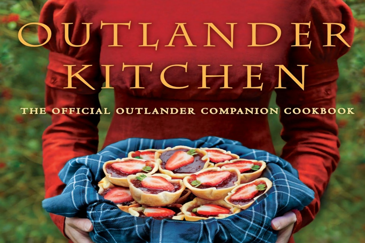 A old-fashioned Scottish woman holding a round serving dish of food. The book title is Outlander Kitchen