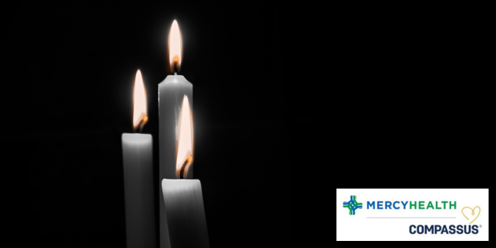 Three candles lit against a dark background.